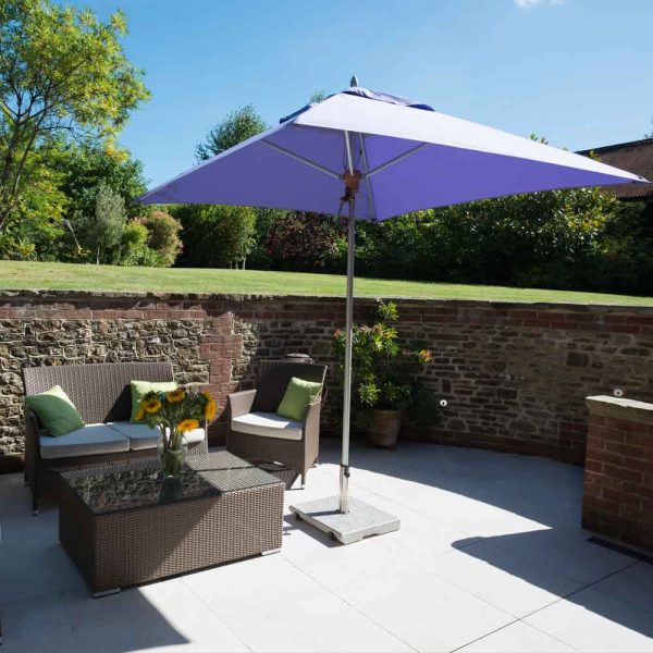 Tradewinds ALUZONE 2.2m square parasol with lilac canvas in terrace setting with flint walls